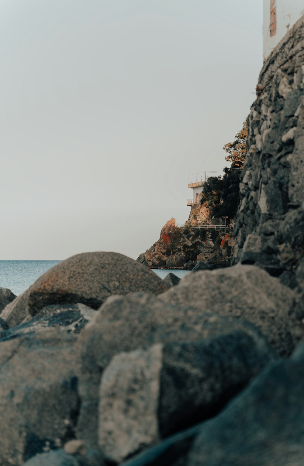 a man standing on a rocky beach next to the ocean