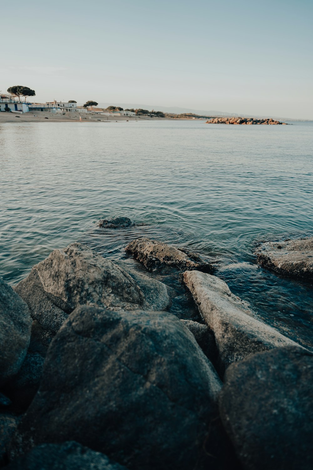 a body of water with rocks in the foreground