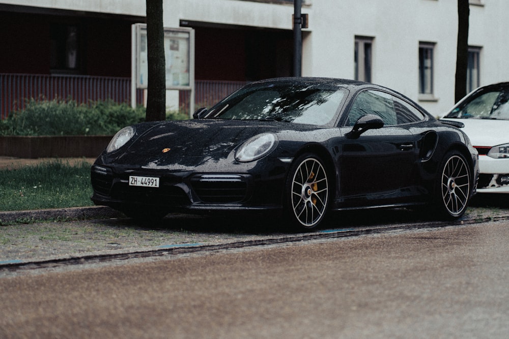 a black porsche parked on the side of the road