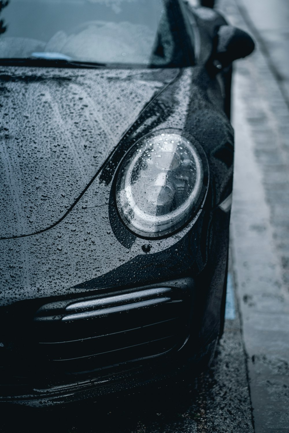 a black porsche parked on the side of the road