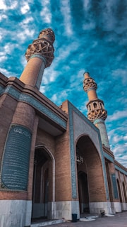 A beautiful mosque with intricate architecture and a blue sky background.