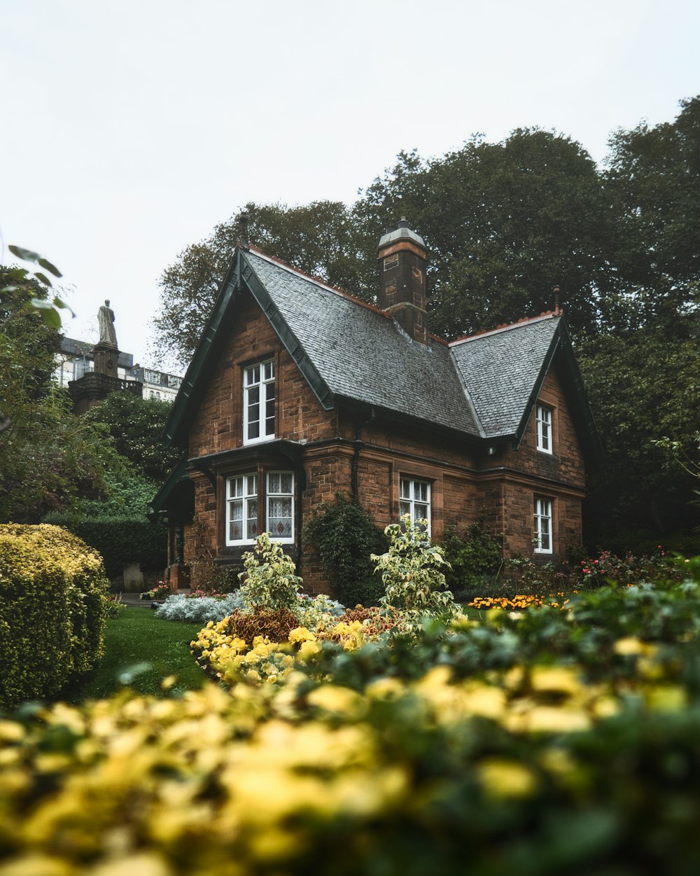 a house with a large garden of flowers in front of it