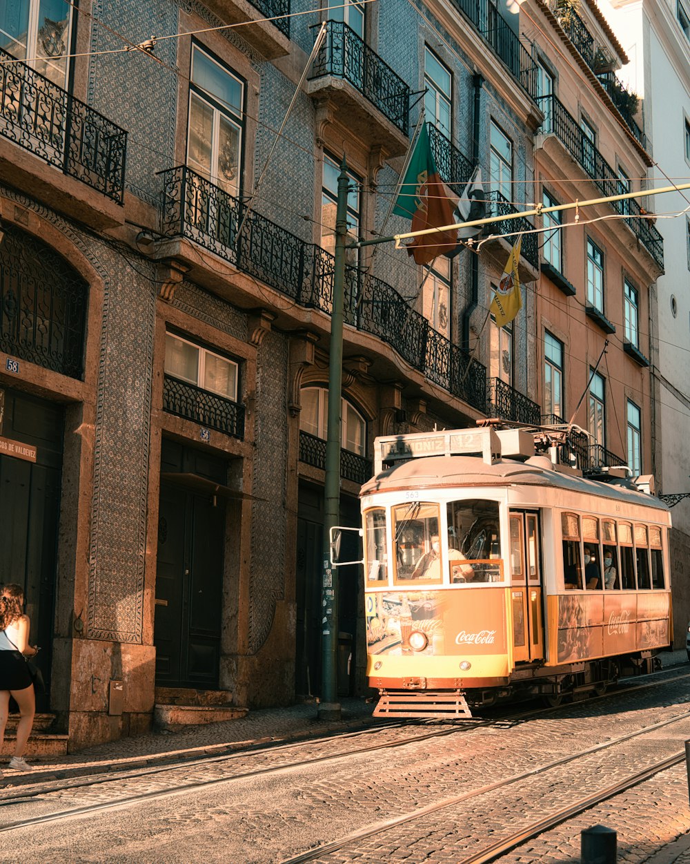 a trolley car on the tracks in front of a building