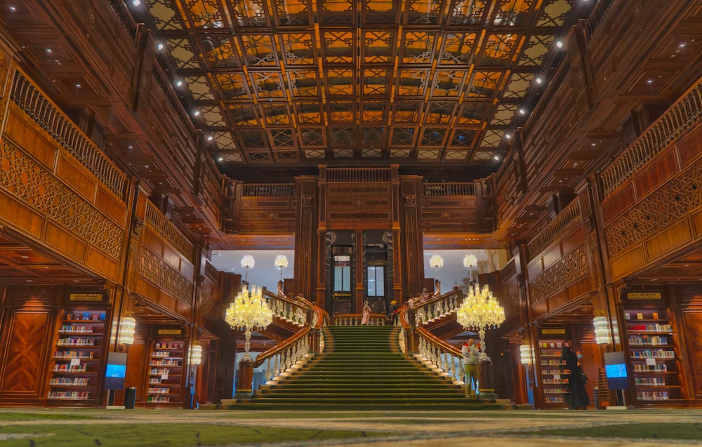 a large library with a staircase and chandelier