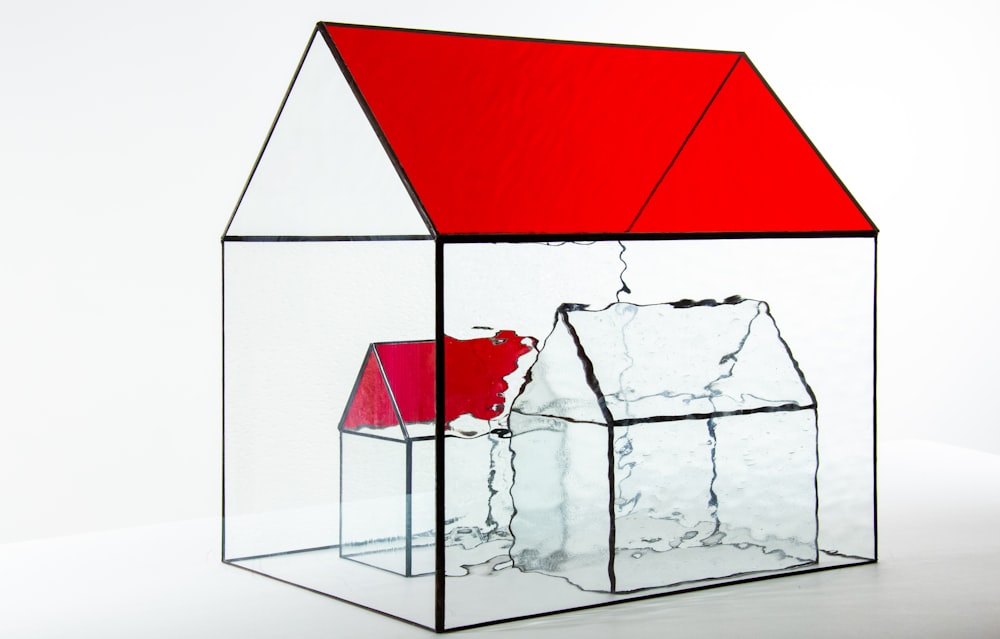 a house made of glass with a red roof