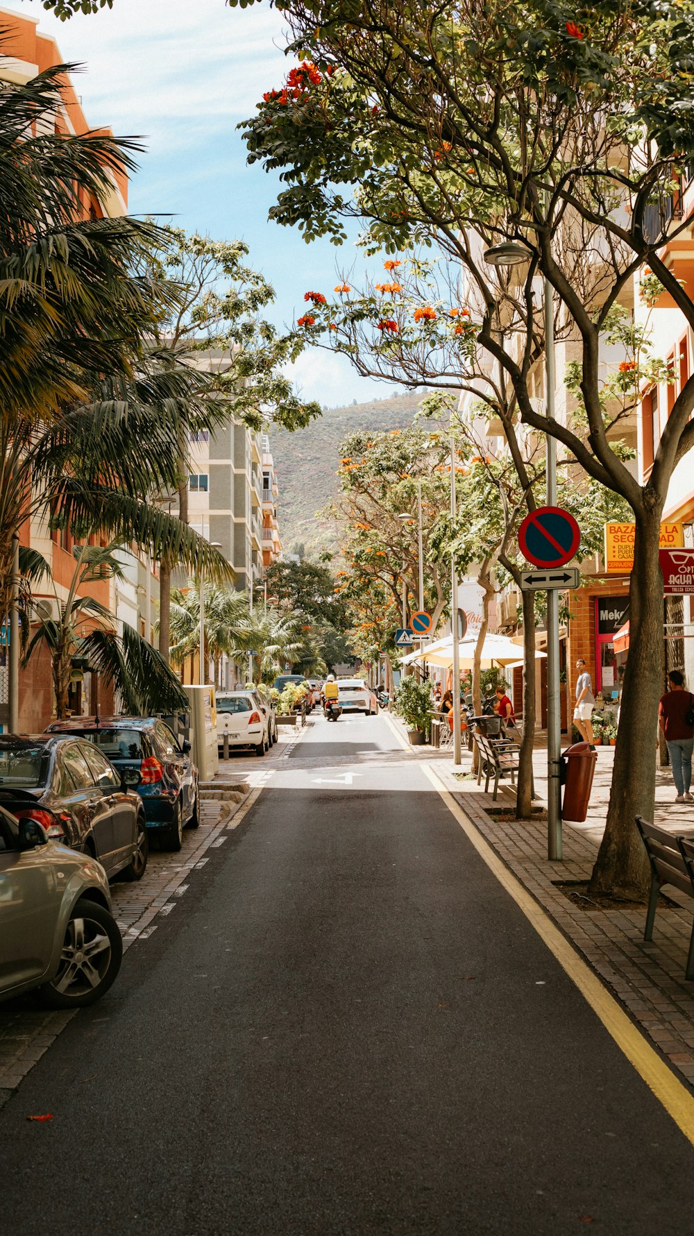 a street lined with parked cars next to tall buildings