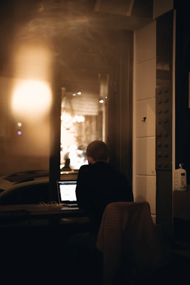 a man sitting in front of a laptop computer