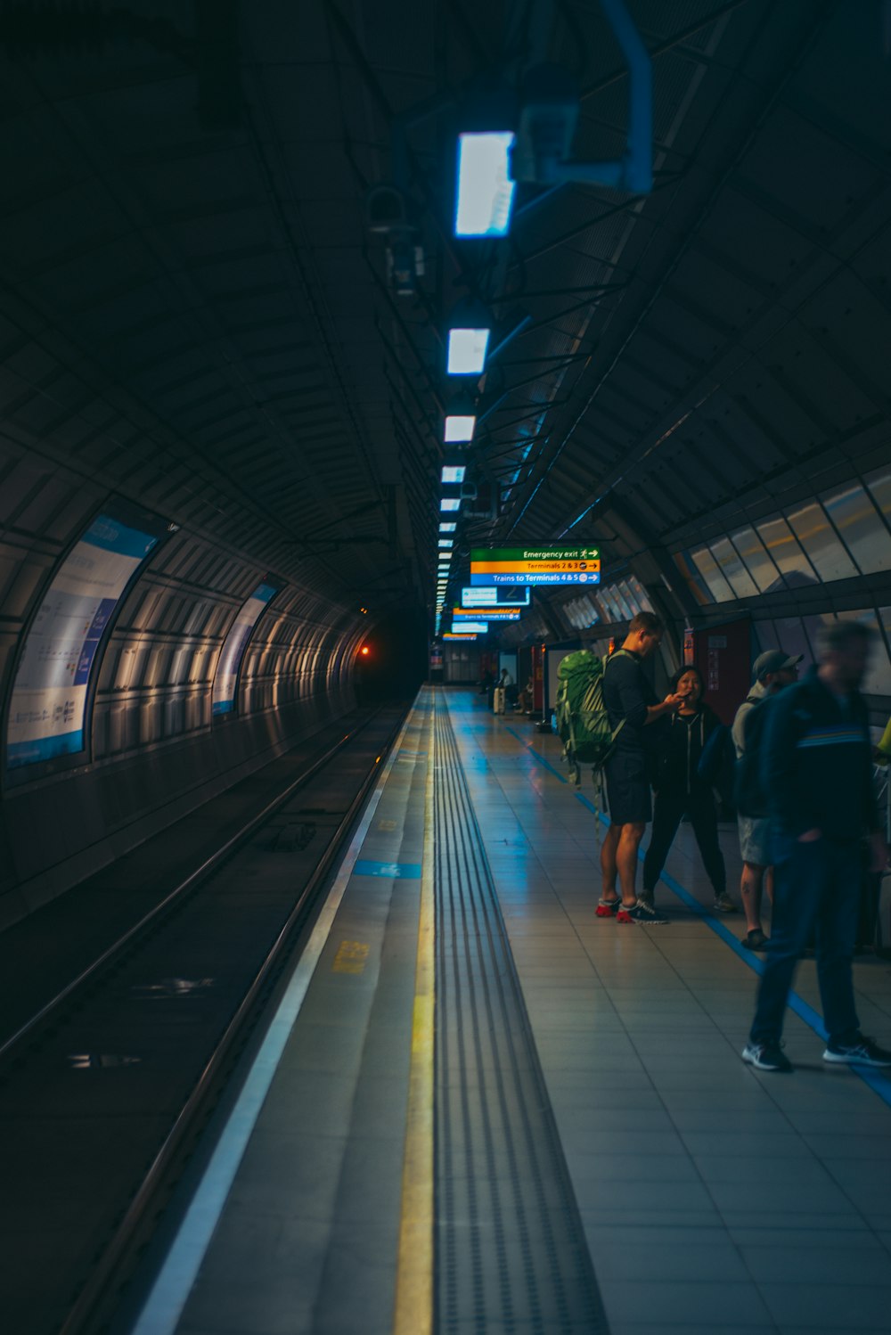 a group of people waiting for a train at a train station