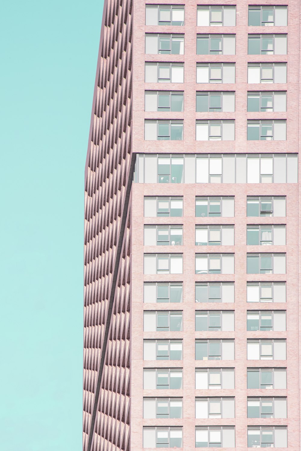 a tall pink building with lots of windows