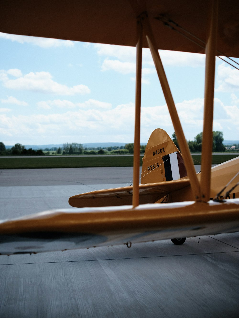 a small yellow airplane sitting on top of an airport tarmac