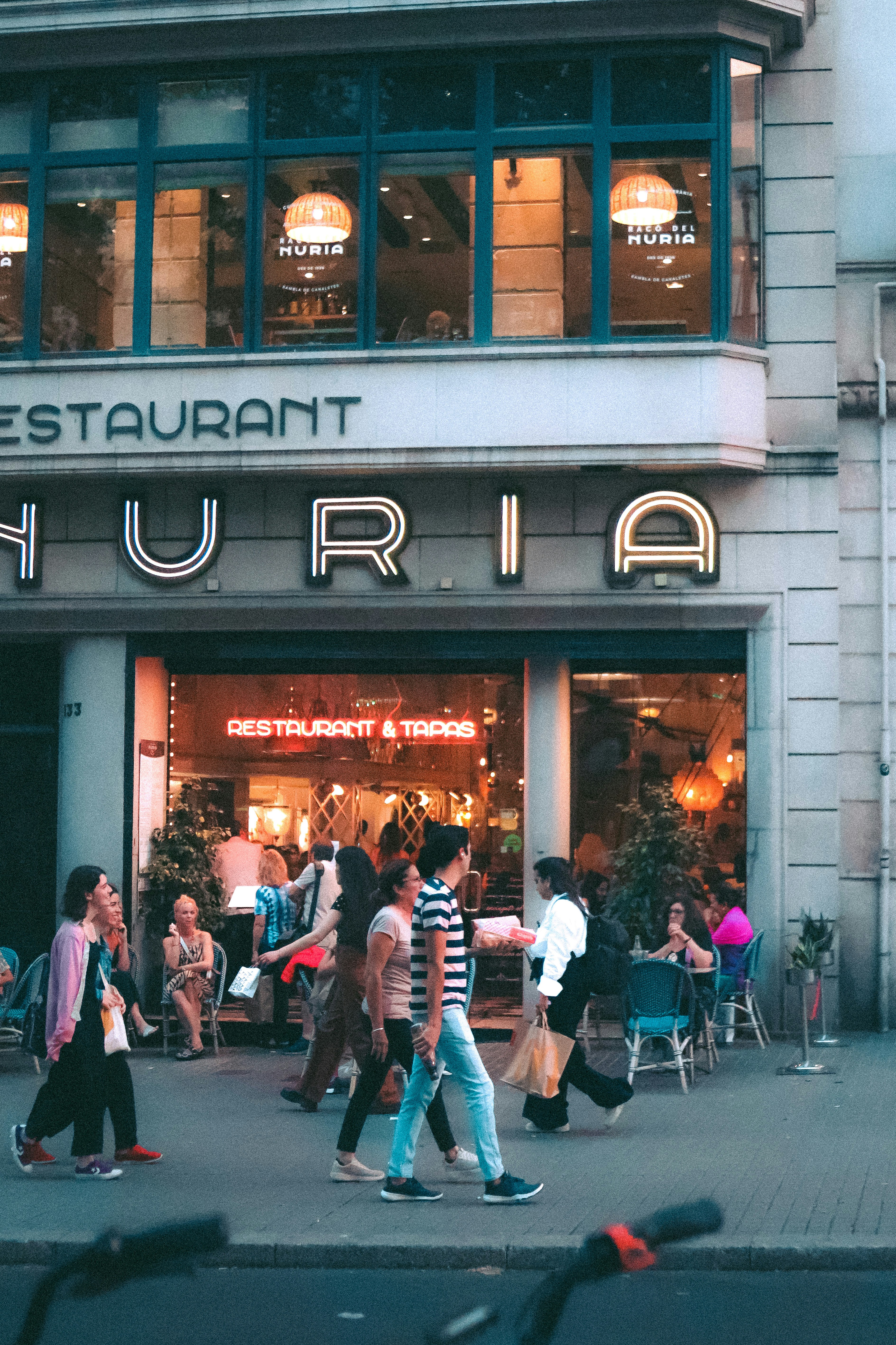 um grupo de pessoas passando por um restaurante