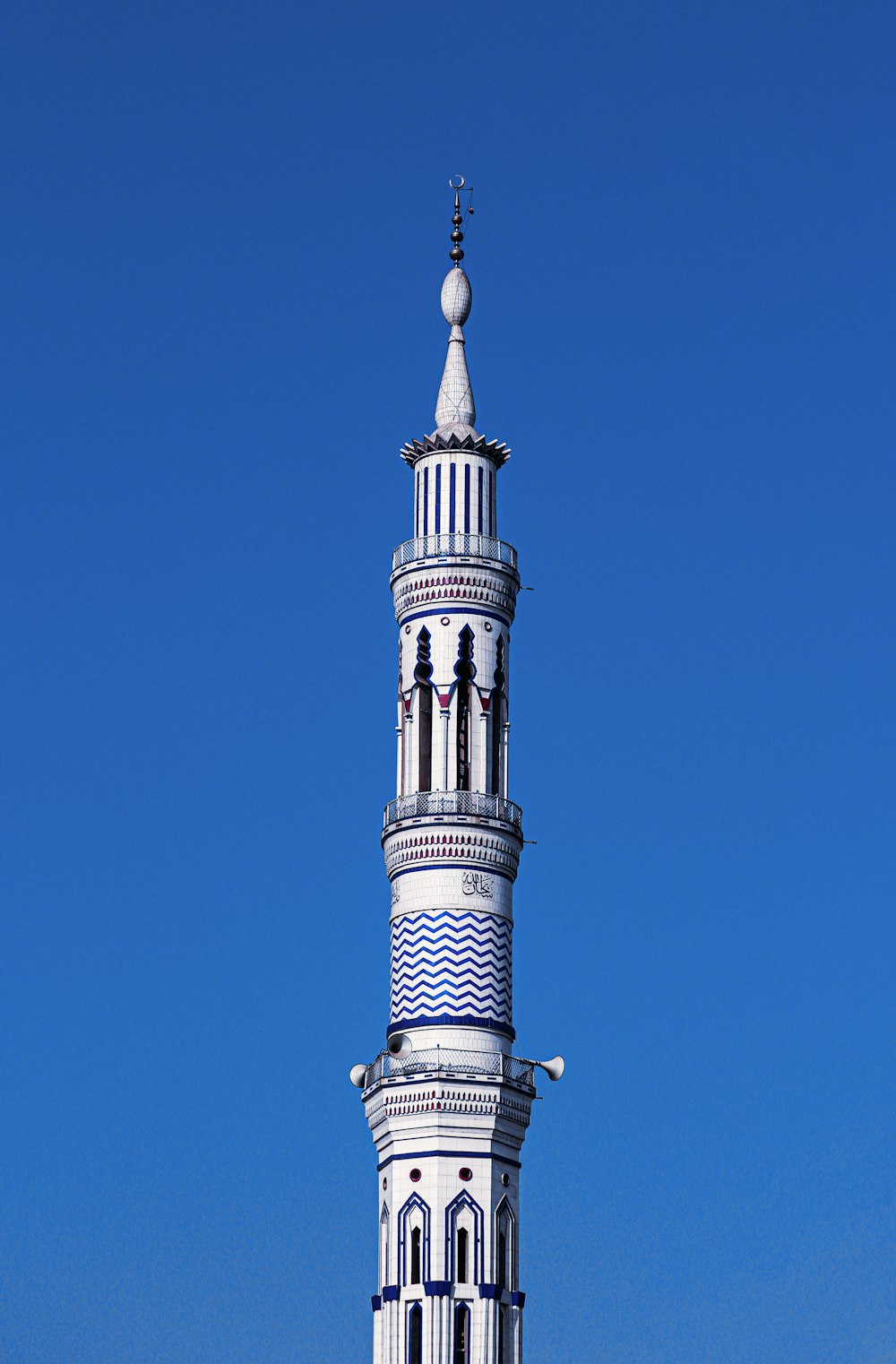 a tall white tower with a clock on it's side