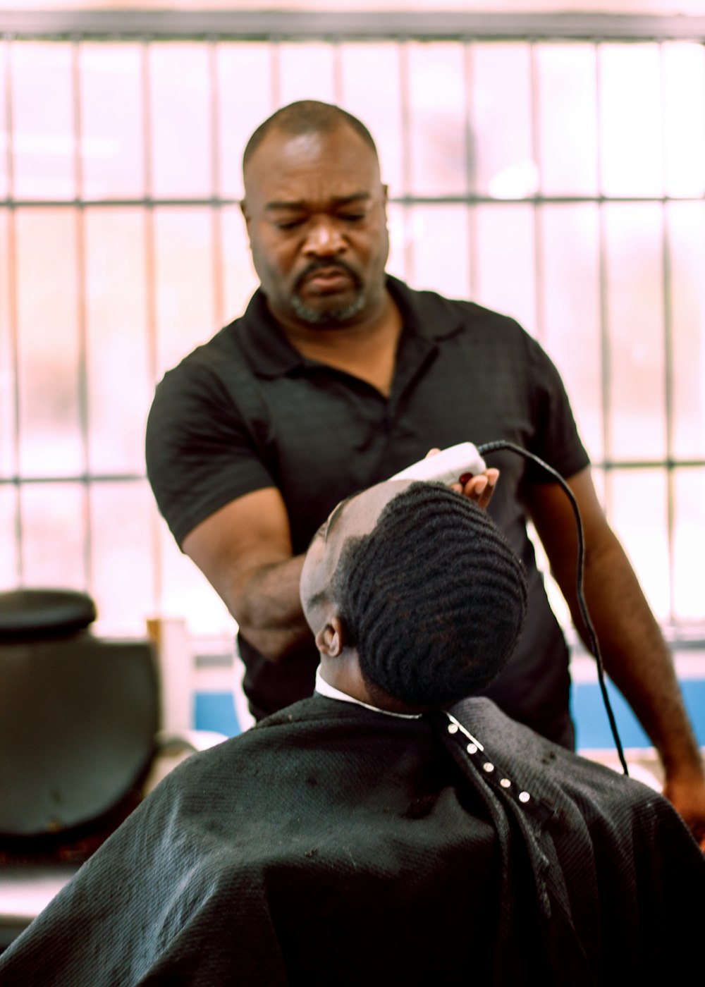 Un homme coupe les cheveux d’un autre homme dans un salon de coiffure