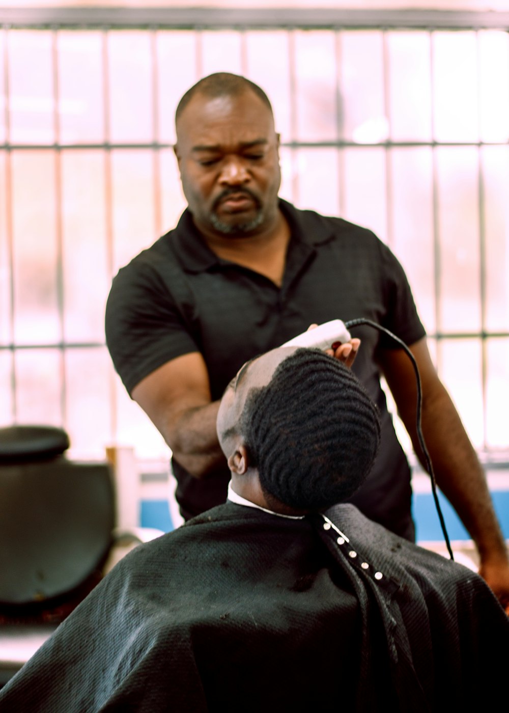 a man cutting another mans hair in a barber shop