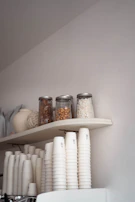 A neatly arranged organizer set in soft cream and taupe hues on a clean, dark grey countertop.
