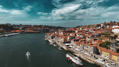 a boat traveling down a river next to a city