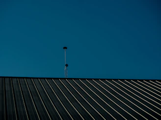 a tall antenna on top of a metal roof