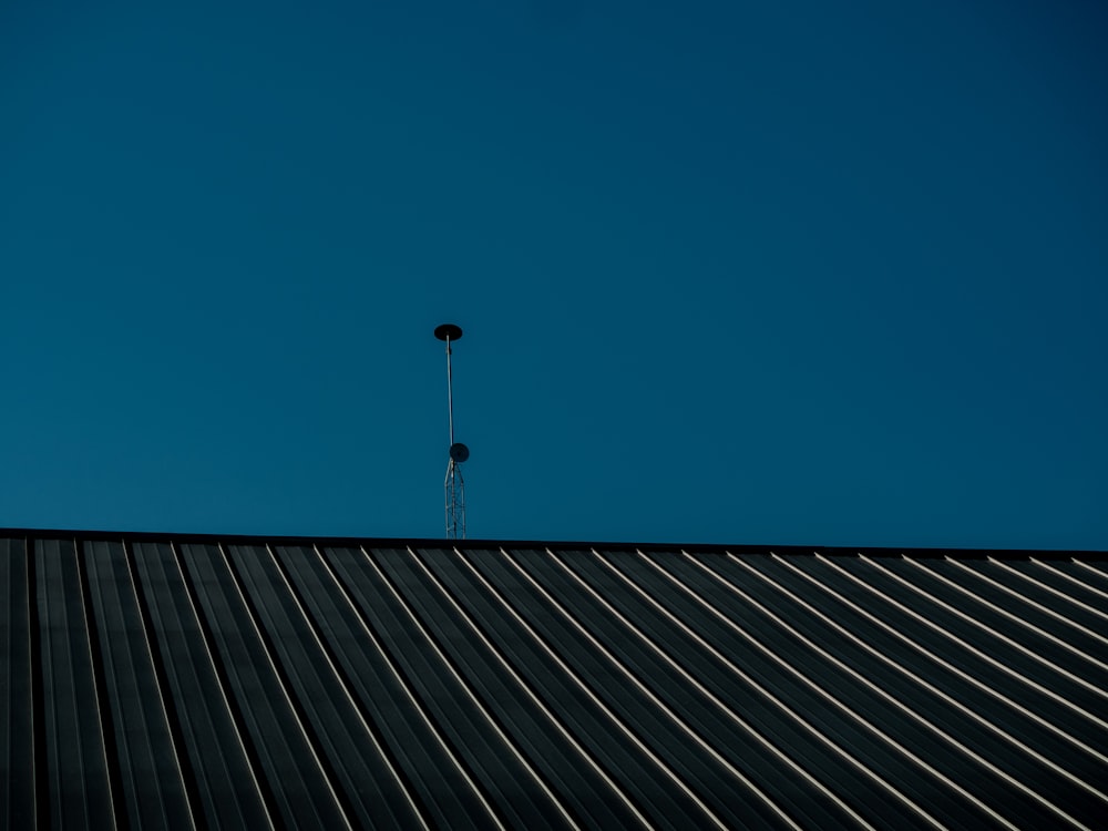 uma antena alta em cima de um telhado de metal