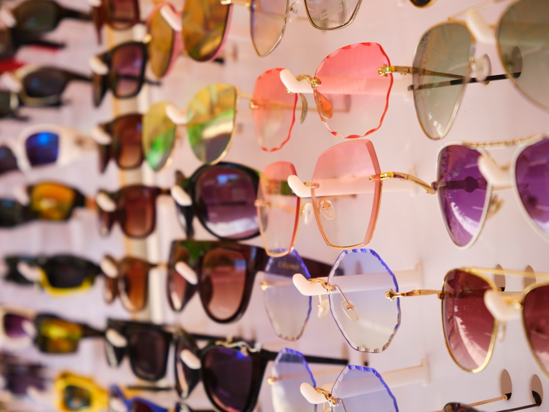 a display of many different colored sunglasses on a wall