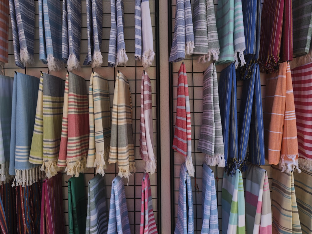 a bunch of towels hanging up on a rack, cotton beautiful towels in a store