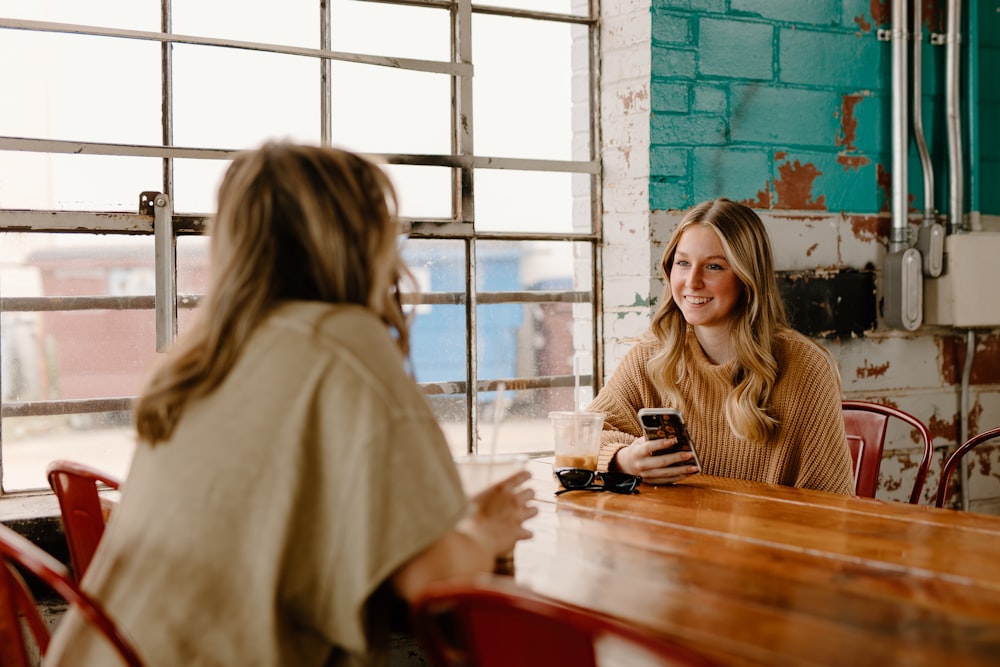 a woman sitting at a table with a cell phone