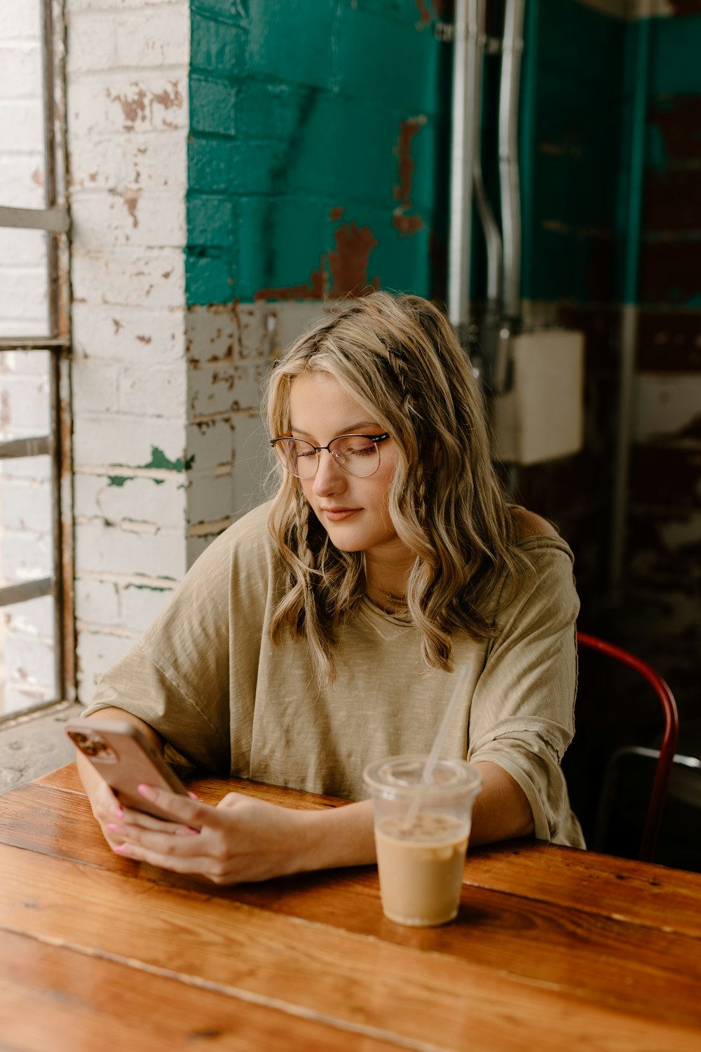 a woman sitting at a table looking at her cell phone