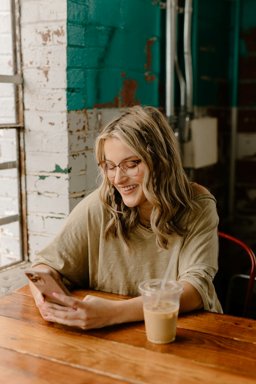 a woman sitting at a table looking at her cell phone