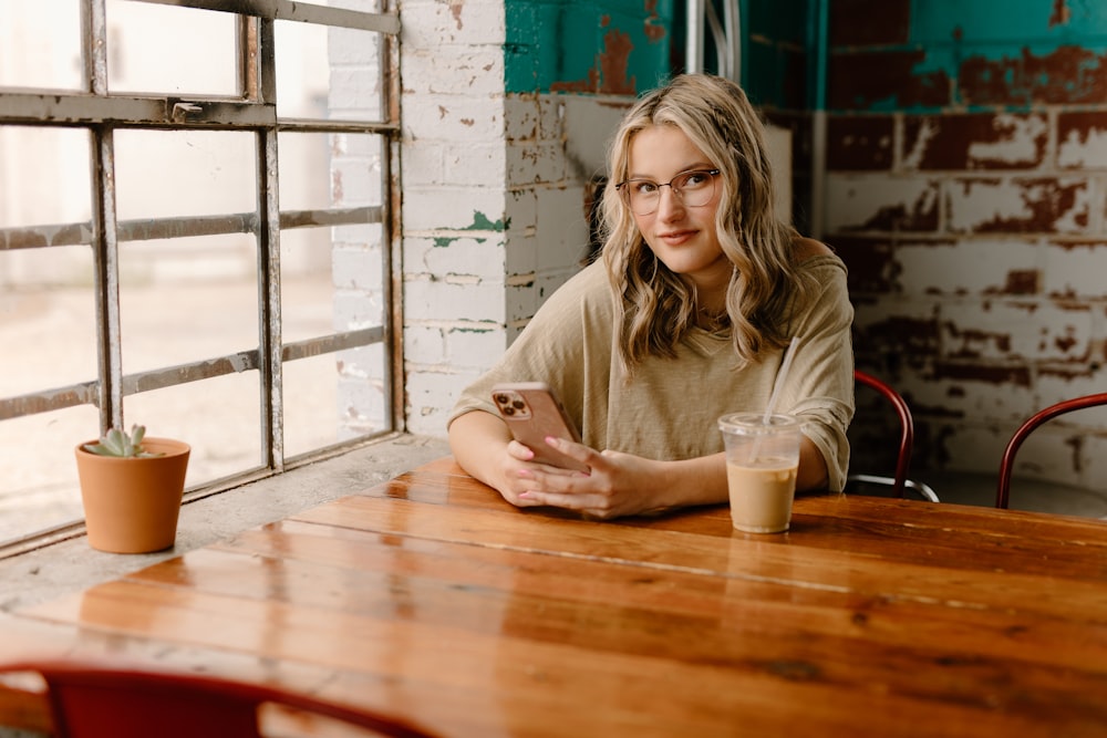 a woman sitting at a table with a cell phone