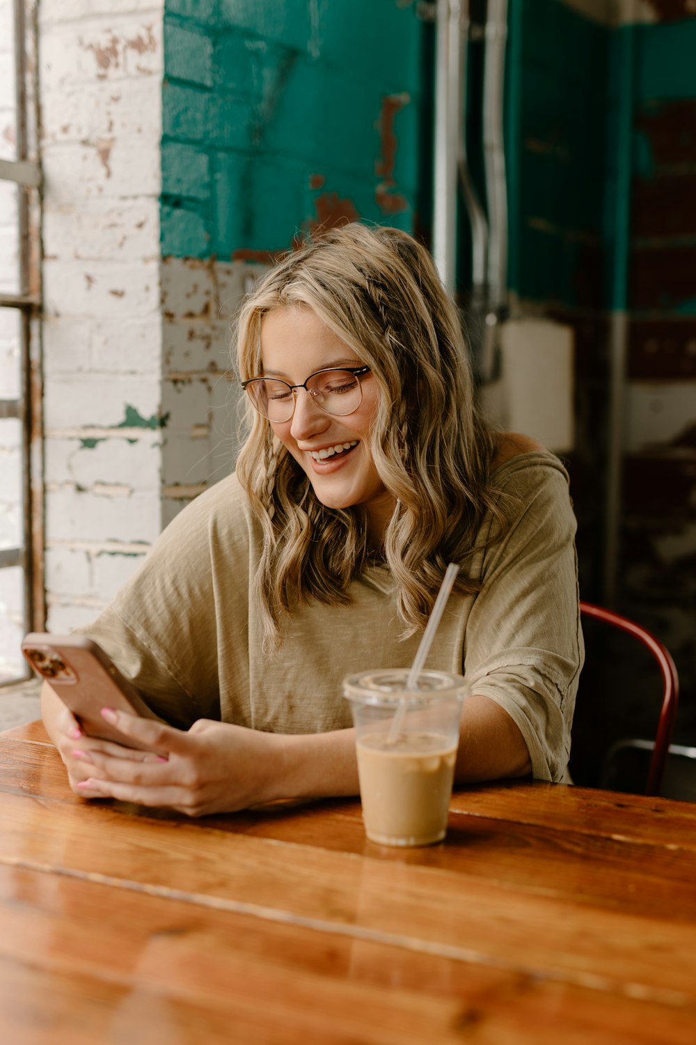 a woman sitting at a table looking at her phone