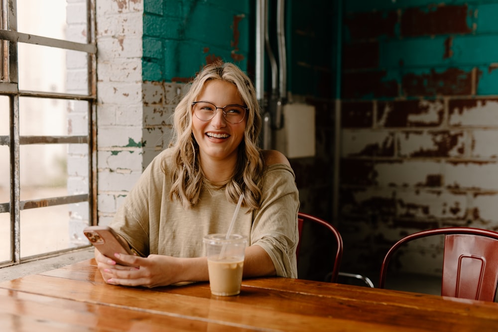 a woman sitting at a table with a cell phone