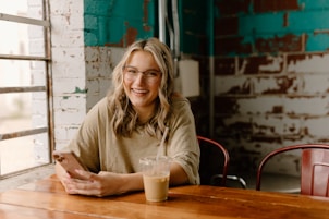 a woman sitting at a table with a cell phone
