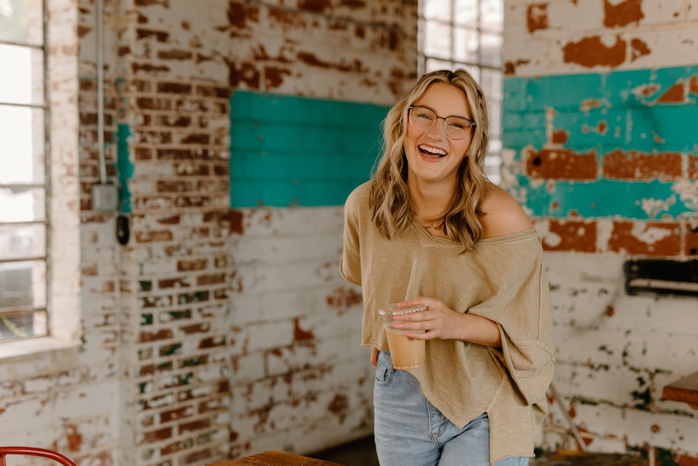 a woman standing in a room with a brick wall