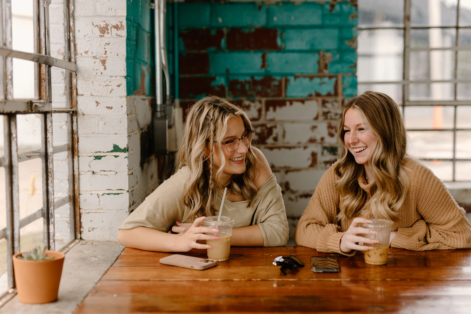 Two women sitting together at a table having a conversation over drinks