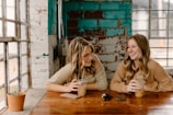 Two people sharing a warm smile over a cup of herbal tea in soft natural light.