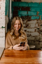 Close-up of a smiling client relaxing in a spa, checking their appointment confirmation on a smartphone.