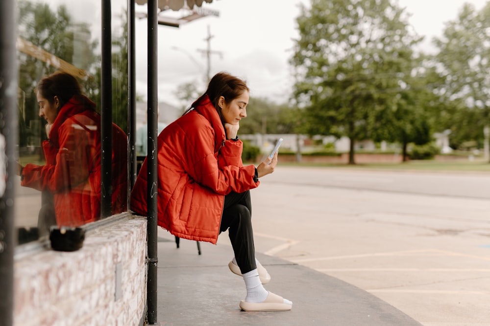 Una mujer sentada en un autobús mirando su teléfono celular