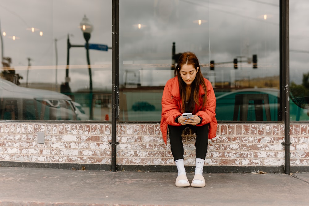 a woman sitting on a bench looking at her cell phone