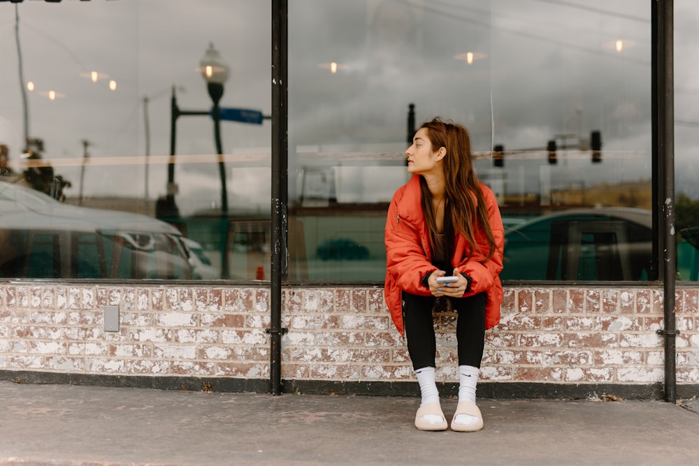 a woman sitting in front of a store window