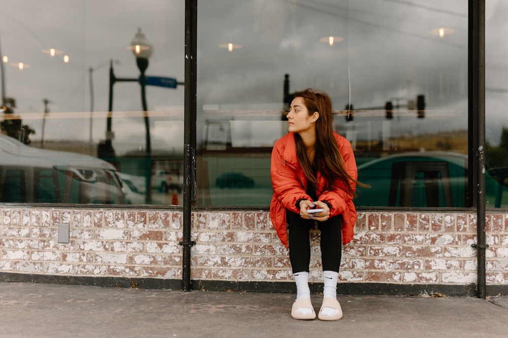 a woman sitting in front of a store window