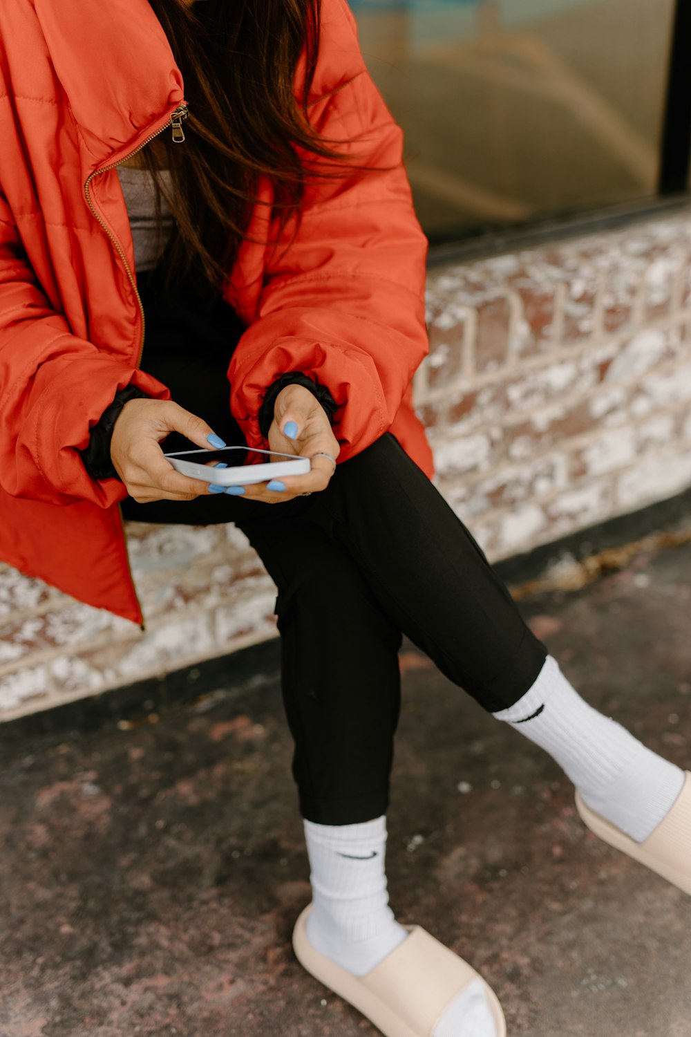 a woman sitting on the ground looking at her cell phone