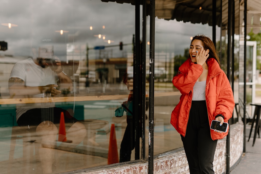 a woman talking on a cell phone in front of a store