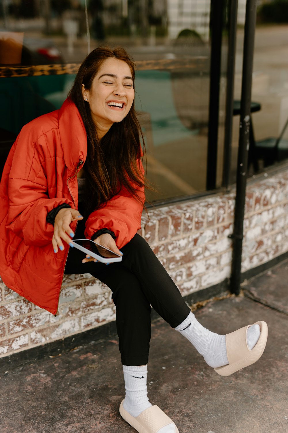 a woman sitting on a window sill holding a tablet