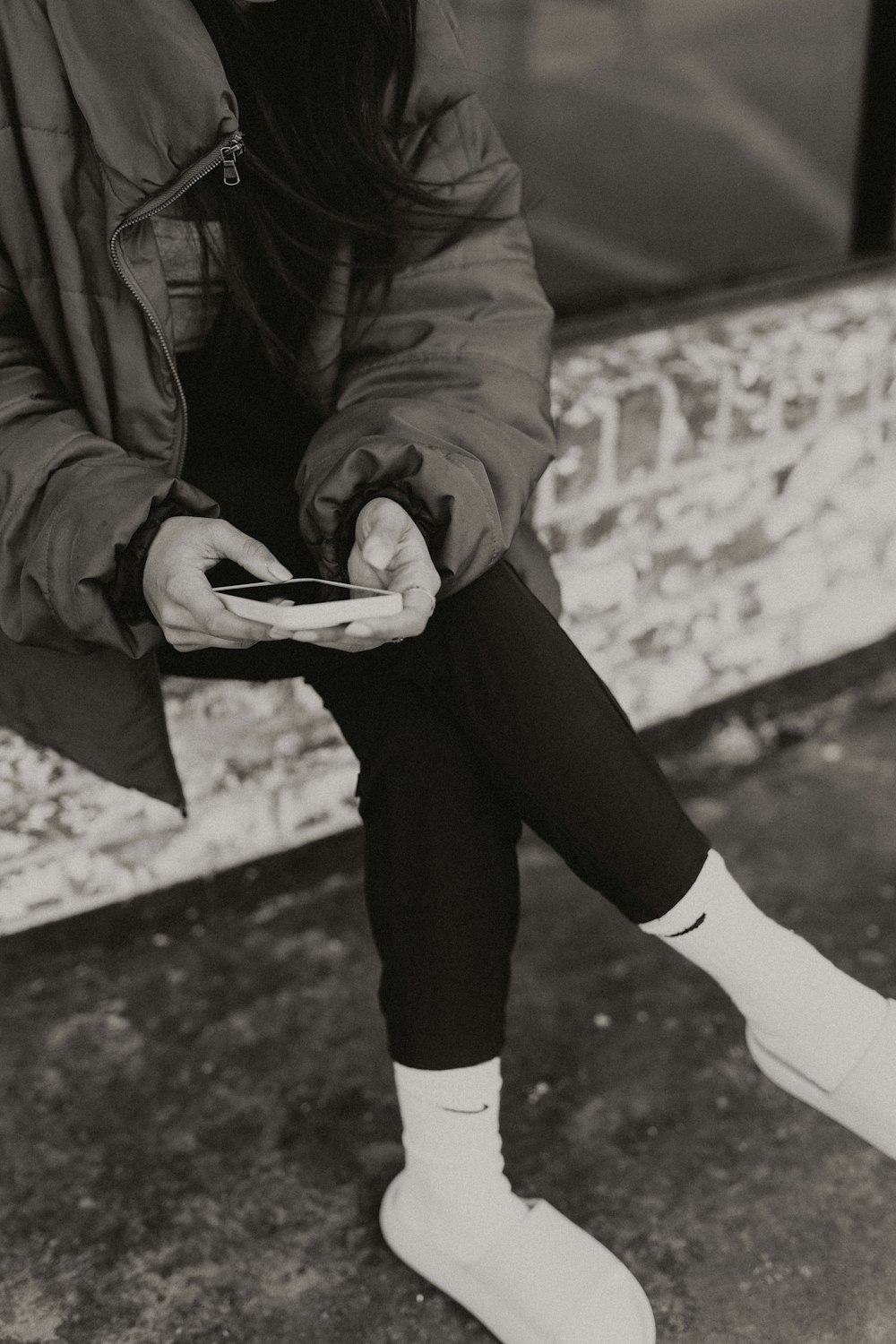 a woman sitting on a bench looking at her cell phone