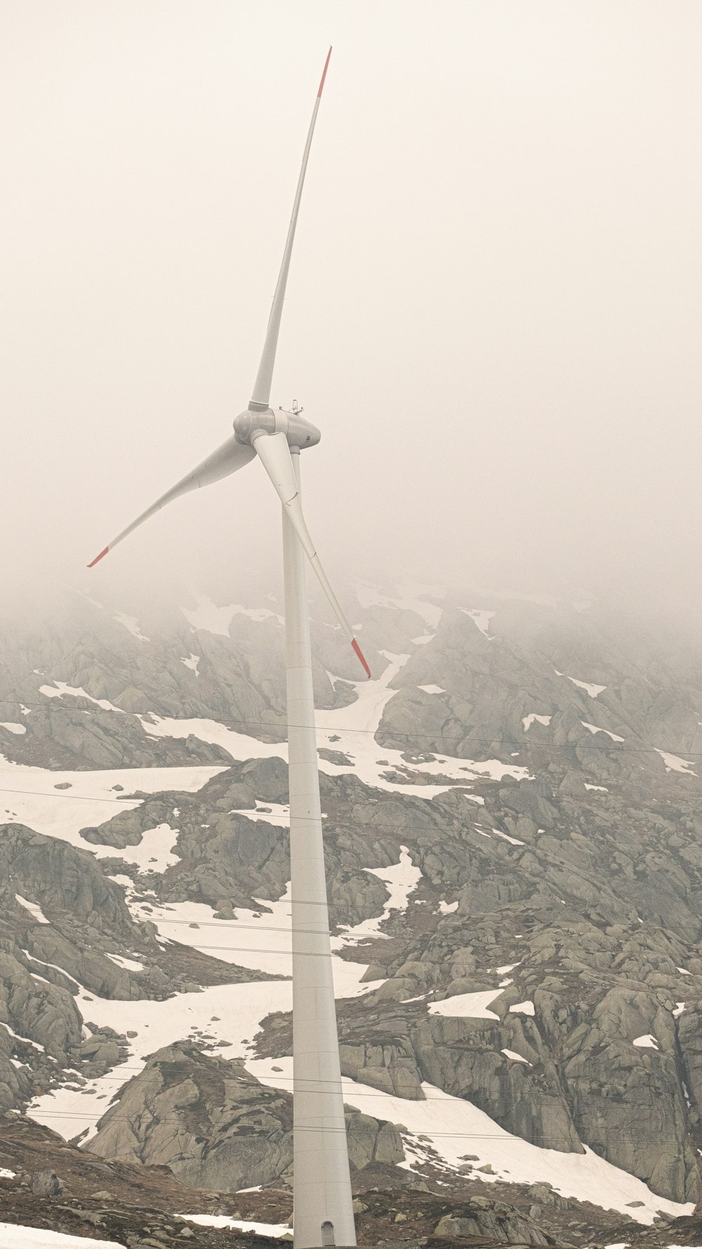 a wind turbine on top of a snow covered mountain