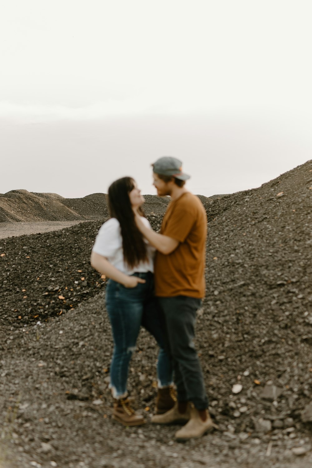 a man and a woman standing on top of a hill