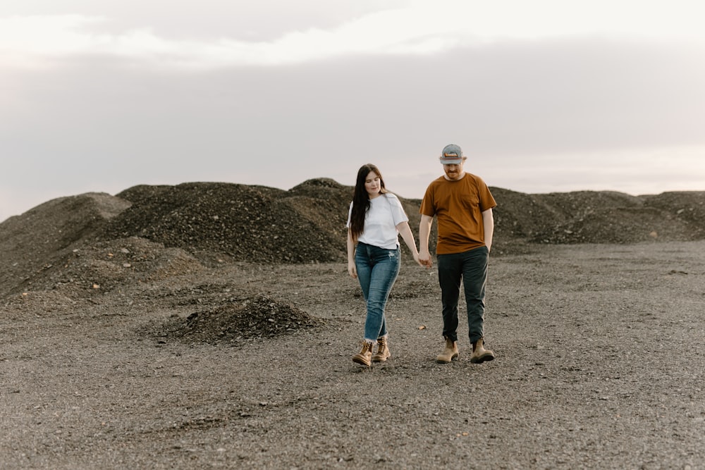 a man and a woman walking through a field