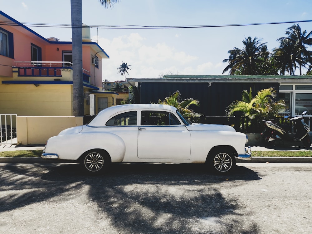 a white car parked in front of a house