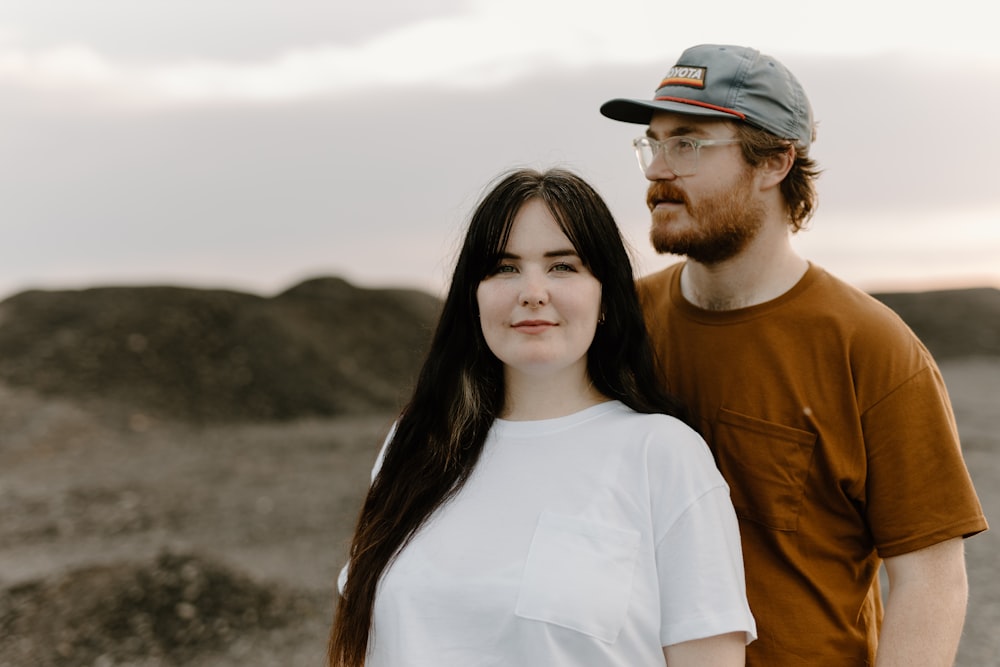 a man standing next to a woman in a desert