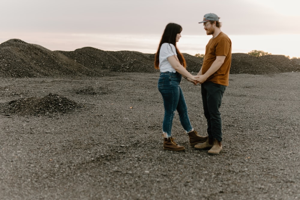 a man and a woman holding hands in a field