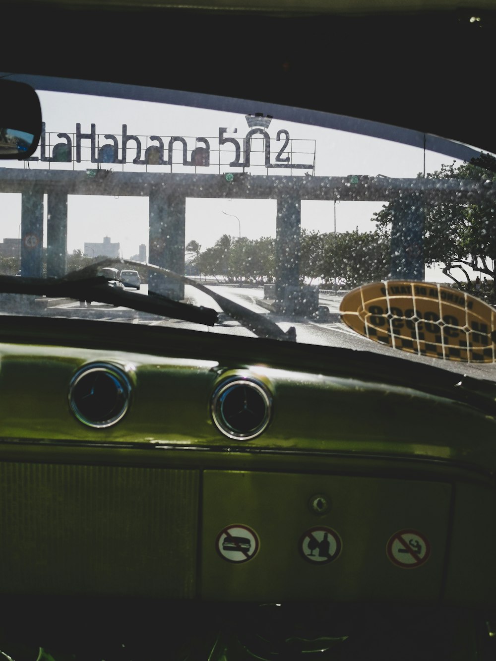 a green car parked in front of a bridge